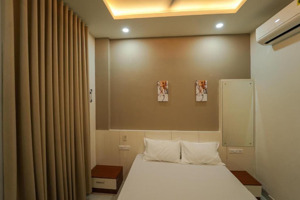 SK Premium Residency في Etakkare: غرفة نوم بسرير أبيض ونافذة