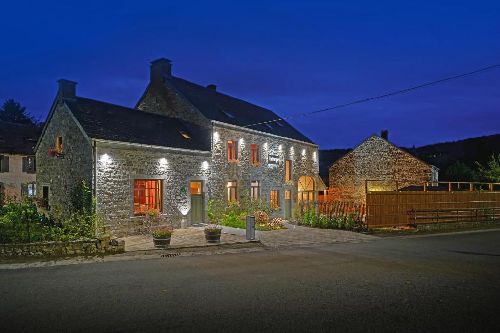 a large stone house with lights on it at La Forge - Chambres d'hôtes en Ardenne in Wellin