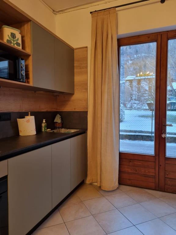 una cucina con un lavandino e una finestra con vista di Appartamento a Monclassico a Monclassico