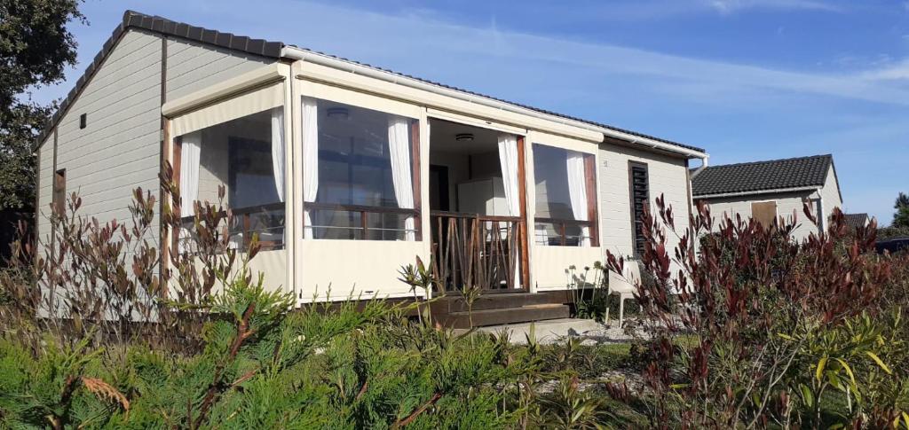Casa blanca pequeña con ventanas grandes de cristal en Chalet dans résidence privée avec piscine couverte, en Marzan