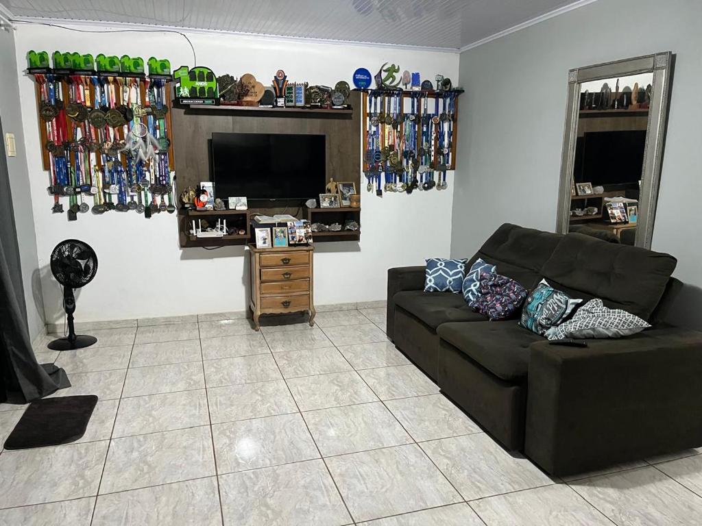 Una sala de estar con un sofá y un televisor de pantalla plana. en Casa Girassol, en Ametista do Sul