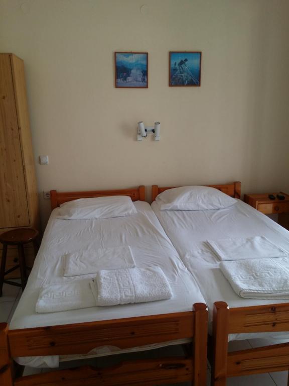 a bedroom with two beds with white sheets and towels at Esperides in Batsi