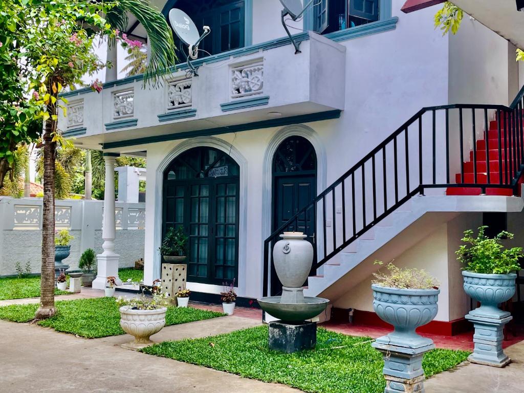 Un edificio con una escalera y jarrones en el patio. en Buono Villa, en Negombo