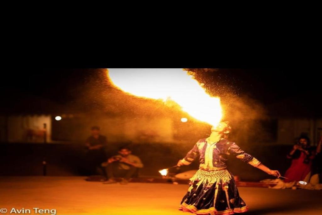 SPOT ON Dream Land Desert Camp في جيلسامر: امرأة ترقص في عرض ناري