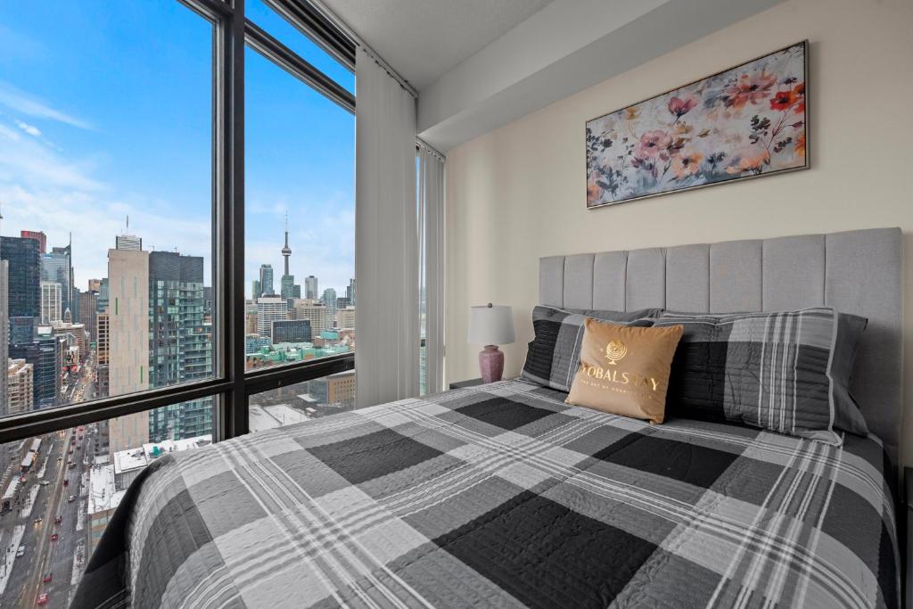 a bedroom with a bed and a large window at High Floor 1 Bedroom Condo City View Downtown Toronto in Toronto