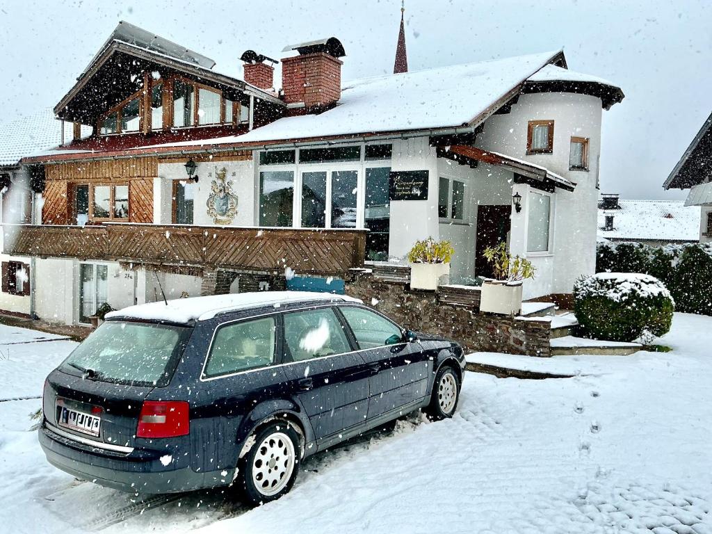 a car parked in front of a house in the snow at Ferienwohnung Vesna & Alex in Elmen