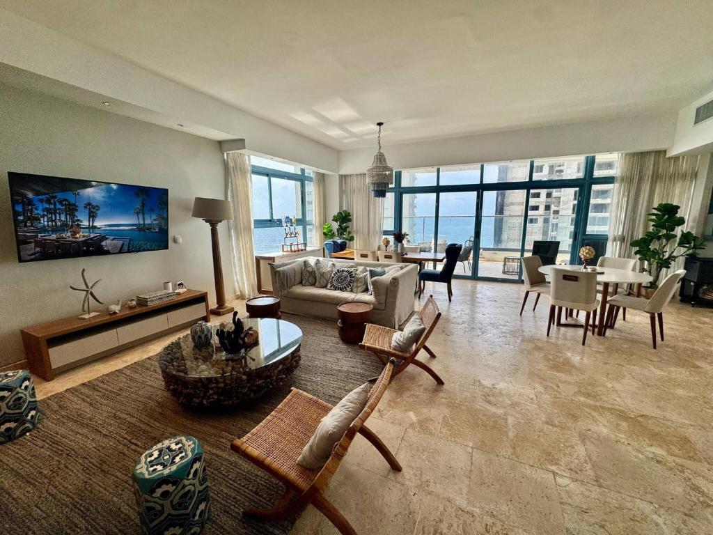 JuanDolio Penthouse 3 bedrooms Beachfront frente a hemingway في Los Corrales: غرفة معيشة بها أريكة وطاولة