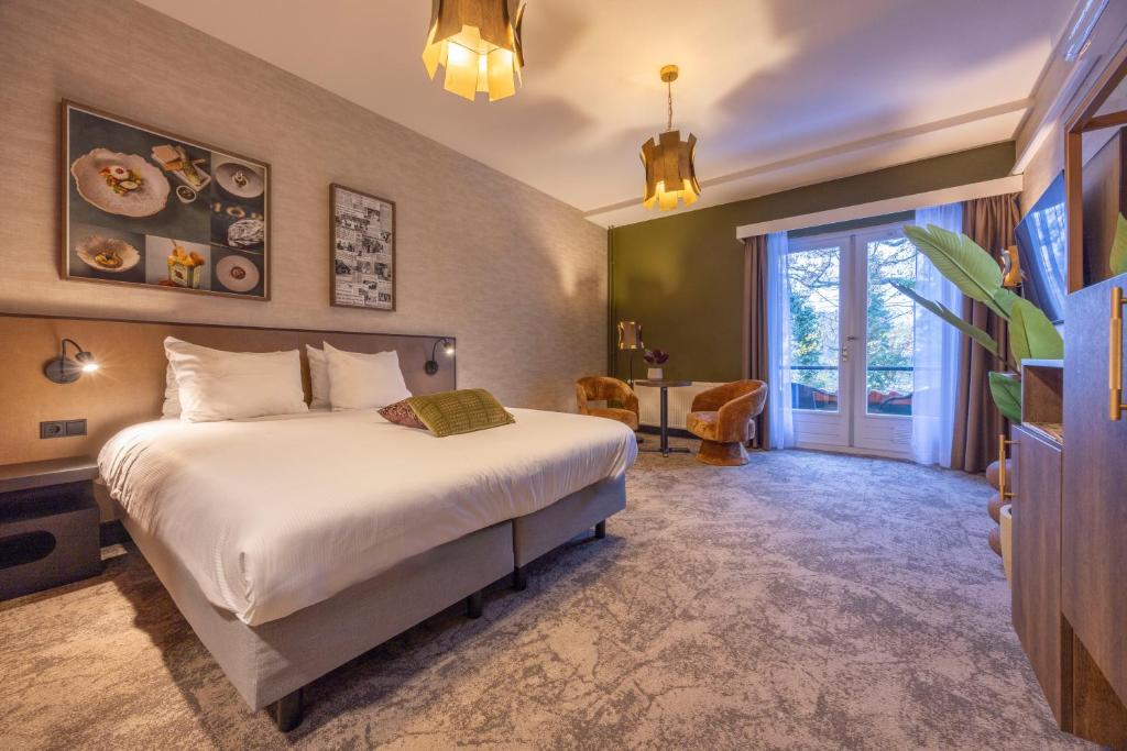 a hotel room with a bed and a window at Fletcher Boutique Hotel De Kromme Dissel in Heelsum