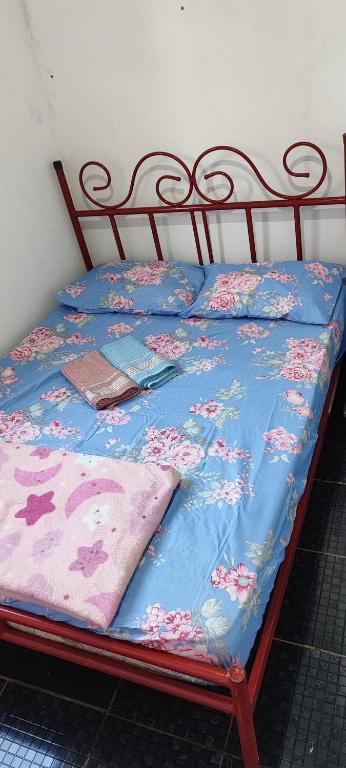 un letto con un piumone blu e fiori sopra di Casa em Araçatuba-SP ad Araçatuba