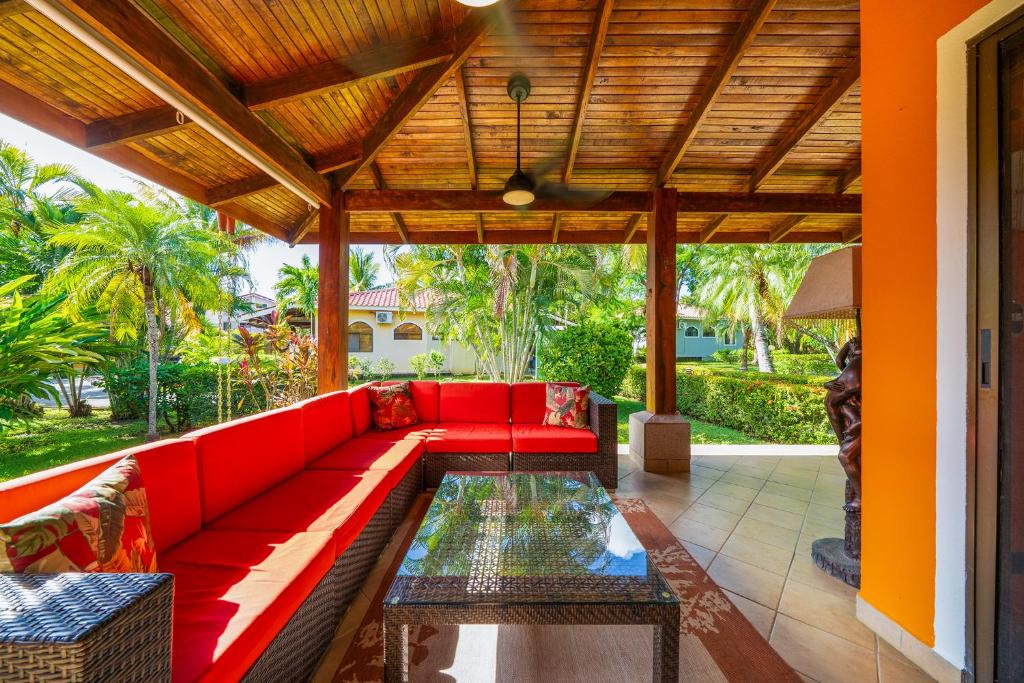 sala de estar con sofá rojo en el patio en BBQ, Pool, Garden, Smart TV, Parking, AC, King Bed, Laundry facilities - Villaggio 376, en Potrero