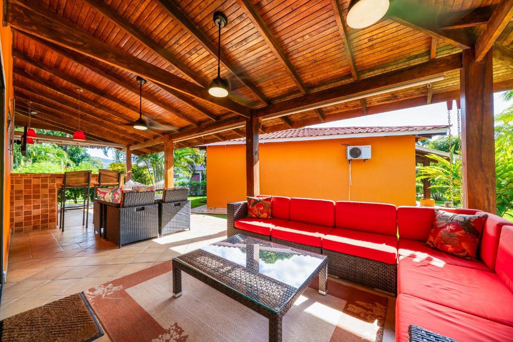 a living room with a red couch and a table at Villaggio 376 - BBQ, Pool, Garden, Smart TV, Parking, AC, King Bed, Laundry facilities in Potrero