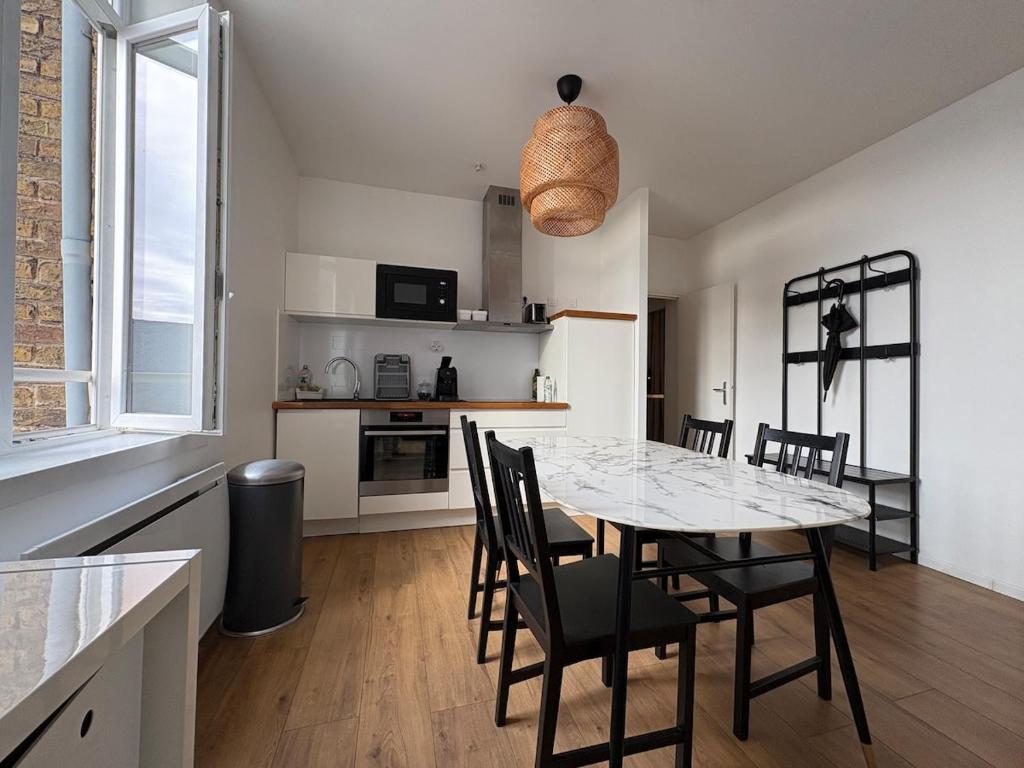a kitchen and dining room with a table and chairs at Digue & Dream - 4-person apartment in Dunkerque
