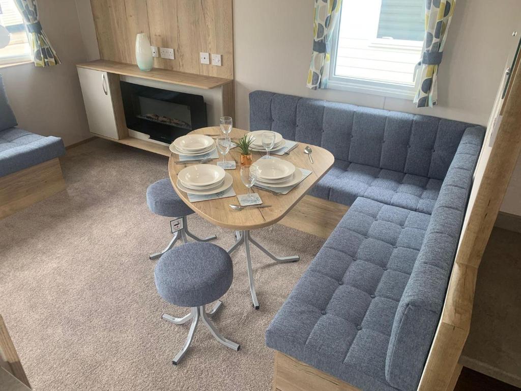 ein Wohnzimmer mit Tisch und Couch in der Unterkunft Lovely 6 Berth Caravan With Free Wi-Fi At Harts Holiday Park, Kent Ref 74068W in Leysdown-on-Sea