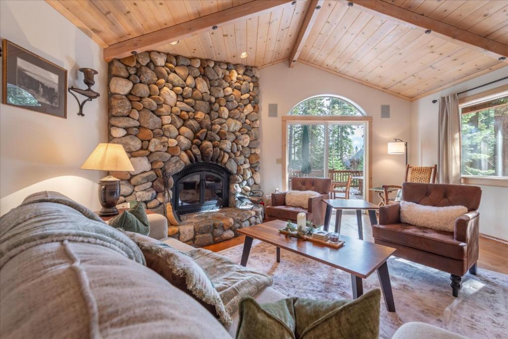 una sala de estar con una gran chimenea de piedra. en Tahoe Pines Beach Retreat home, en Tahoe Pines