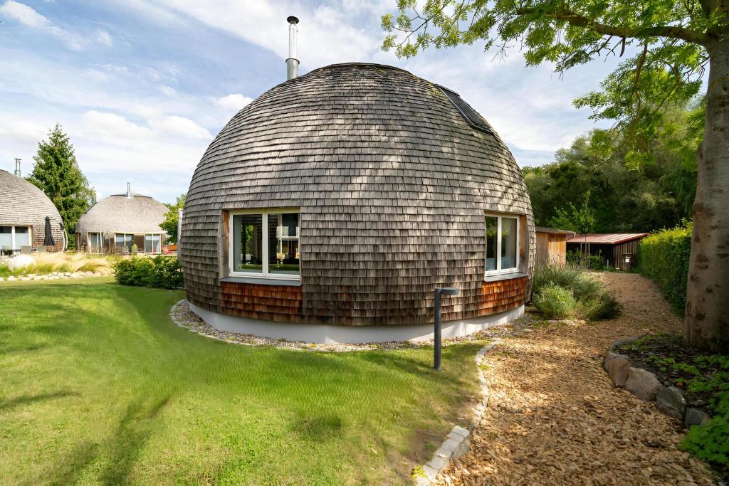 ein kuppelförmiges Haus auf einem Hof in der Unterkunft Kugelhaus Phoebe Charmantes Kugelhaus aus Holz am Waldrand des Tollensesees in Wustrow