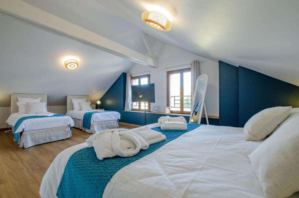 two beds in a room with blue walls at les rives champenoises in Buxeuil
