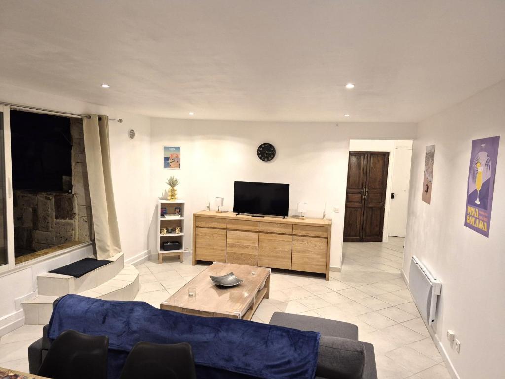 a living room with a couch and a tv at rez de villa confort & grand extérieur in Furiani