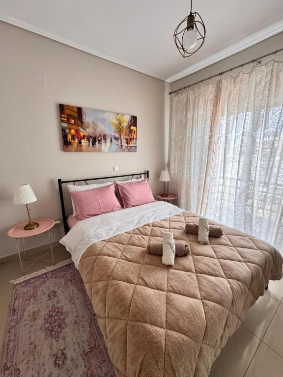 een slaapkamer met een groot bed met roze kussens bij Zoe's Luxury Homes in Alexandroupoli
