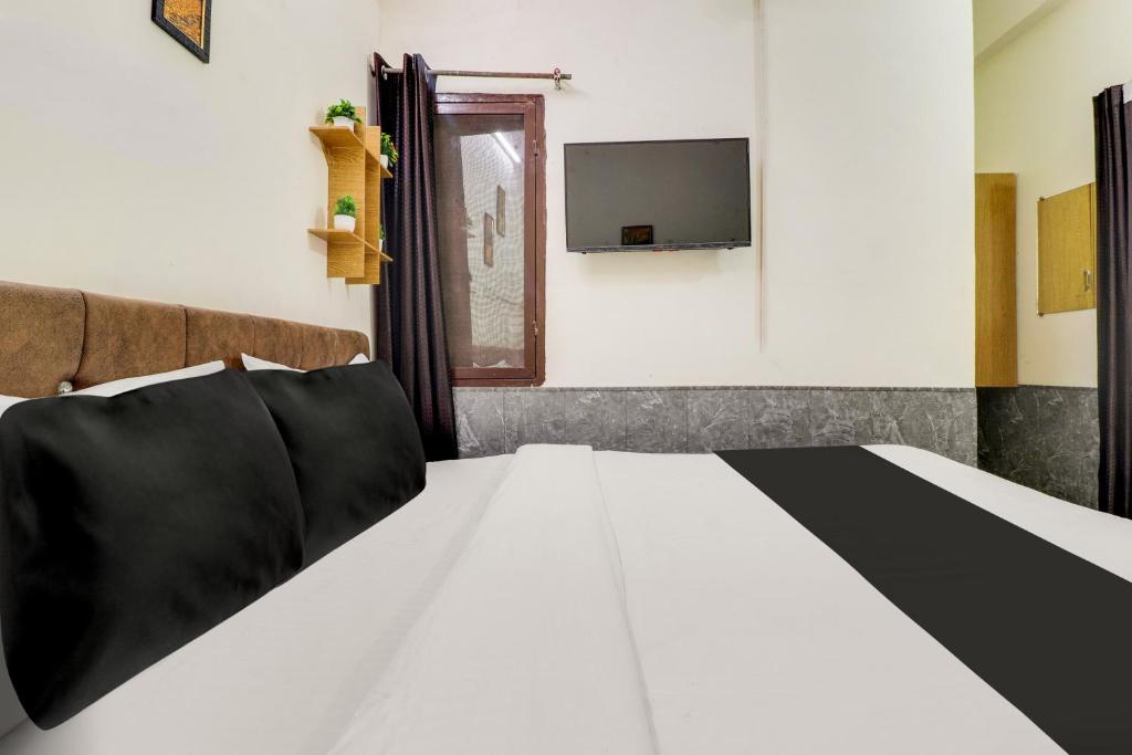 a bedroom with a bed and a tv on the wall at Hotel O Second Home Residency in Dehradun