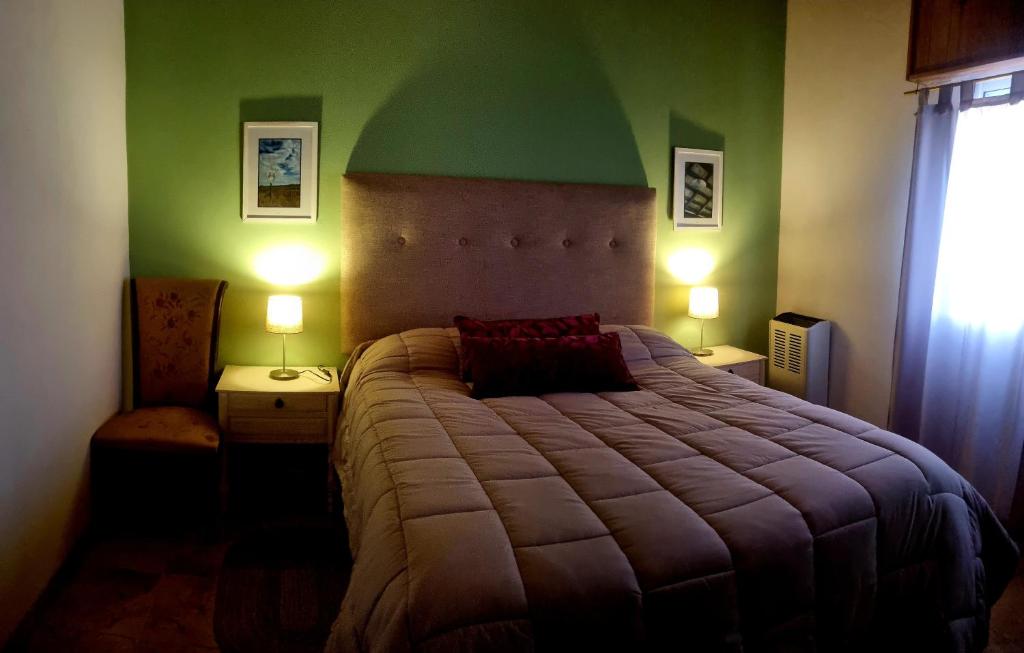 Un dormitorio con una cama grande con una pared verde. en Casa Casuarina, en General Belgrano
