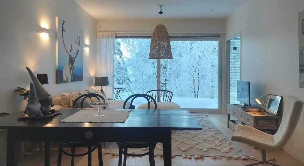 ein Wohnzimmer mit Esstisch und ein Zimmer mit Fenster in der Unterkunft Arctic Luxury Home in Rovaniemi