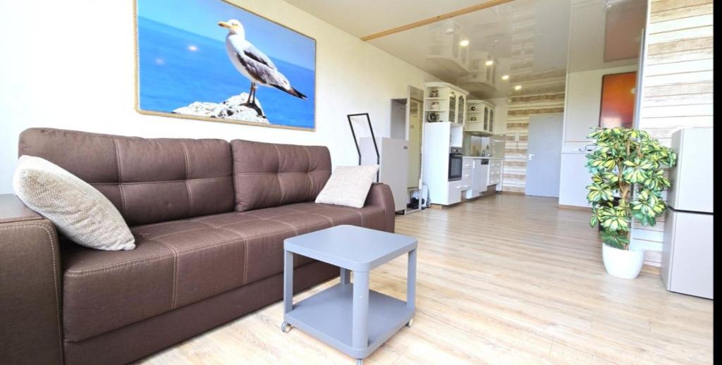 ein Wohnzimmer mit einem braunen Sofa und einem Tisch in der Unterkunft Ferienwohnung Möwe in Schönberg