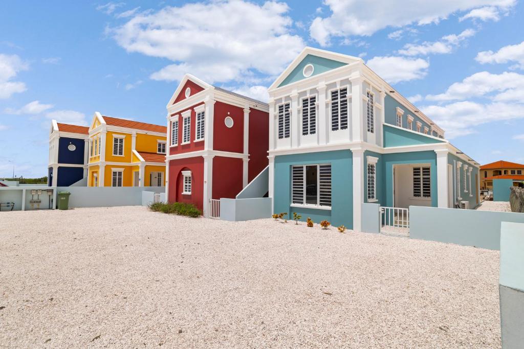 a group of colorful houses on a beach at Kasa Blou in Kralendijk