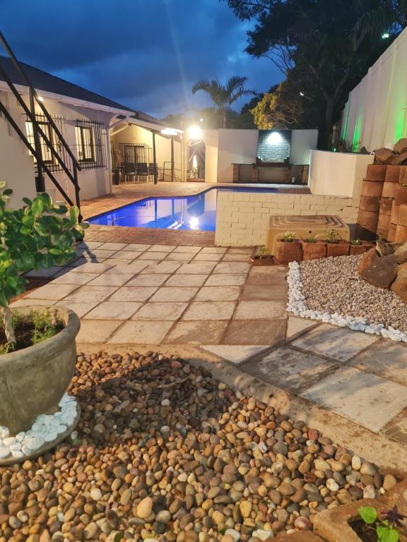 een achtertuin met een zwembad in de nacht bij Melodia V in Durban