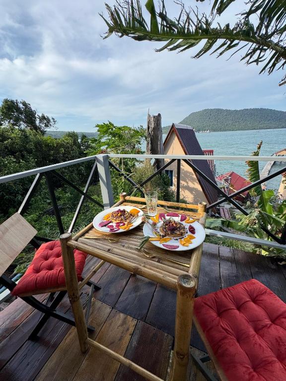 a table with two plates of food on a deck at Sea PoeTree in Koh Rong Sanloem