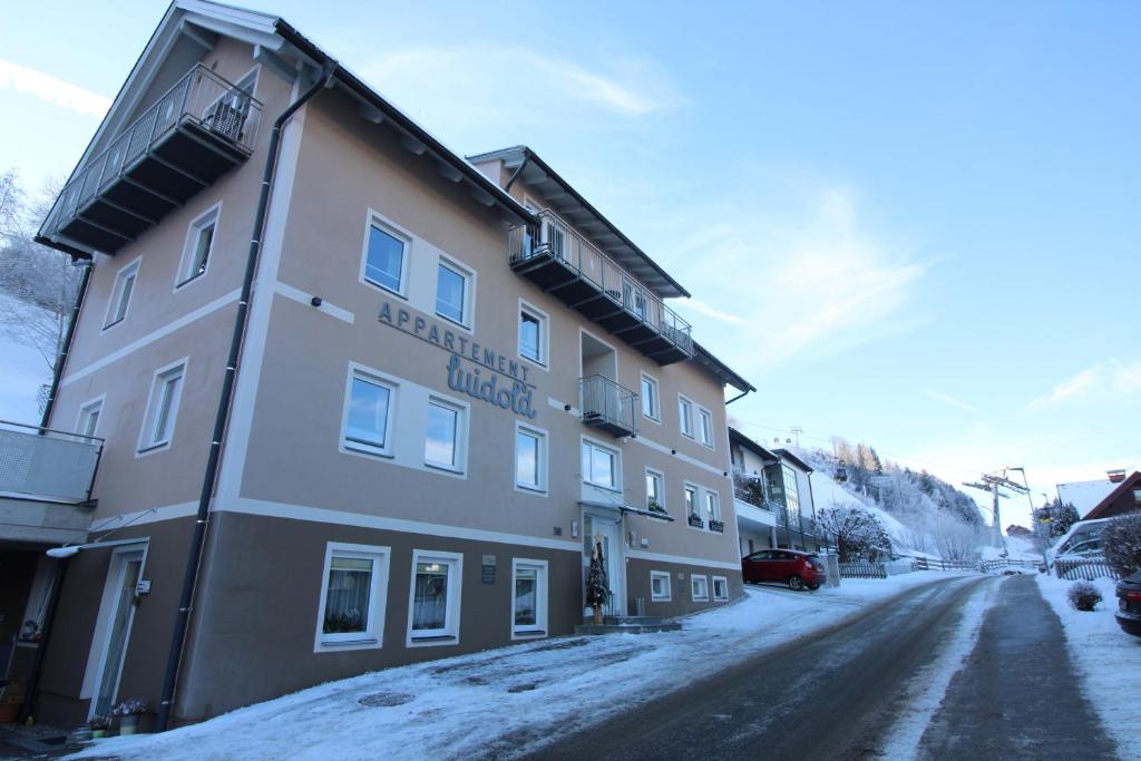 a building on the side of a snow covered street at Apartments Luidold in Schladming