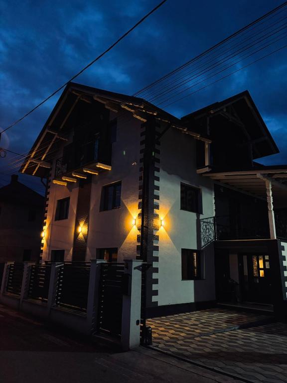 a house with lights on the side of it at night at Casa David in Câmpulung Moldovenesc