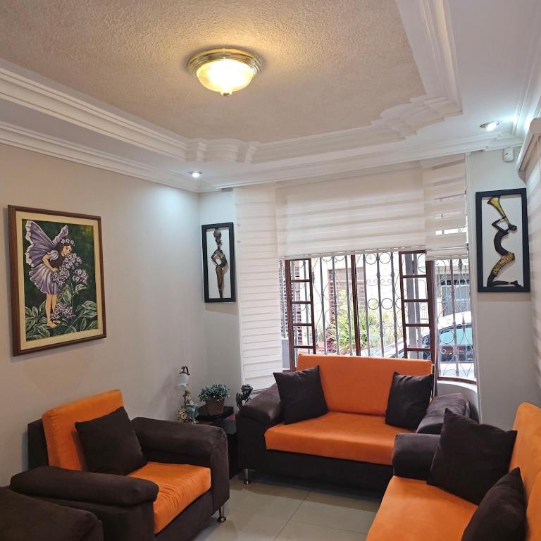 un soggiorno con due sedie e un divano di Casa grande cerca de todo a Cuenca