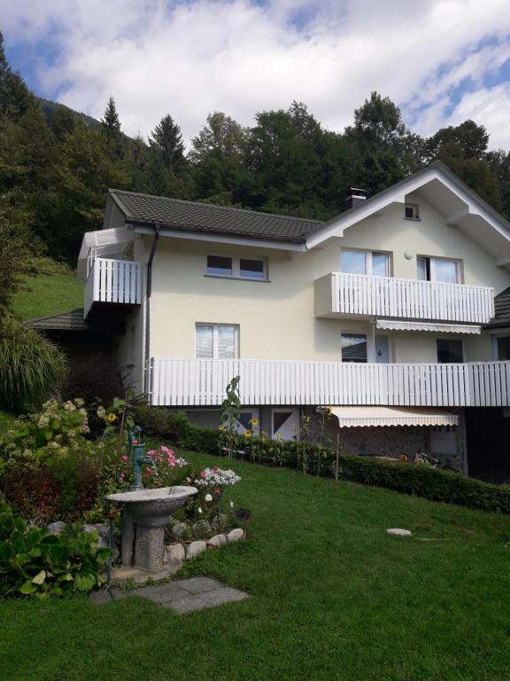 una casa blanca con una valla y un patio en Širovnik Apartment en Begunje na Gorenjskem