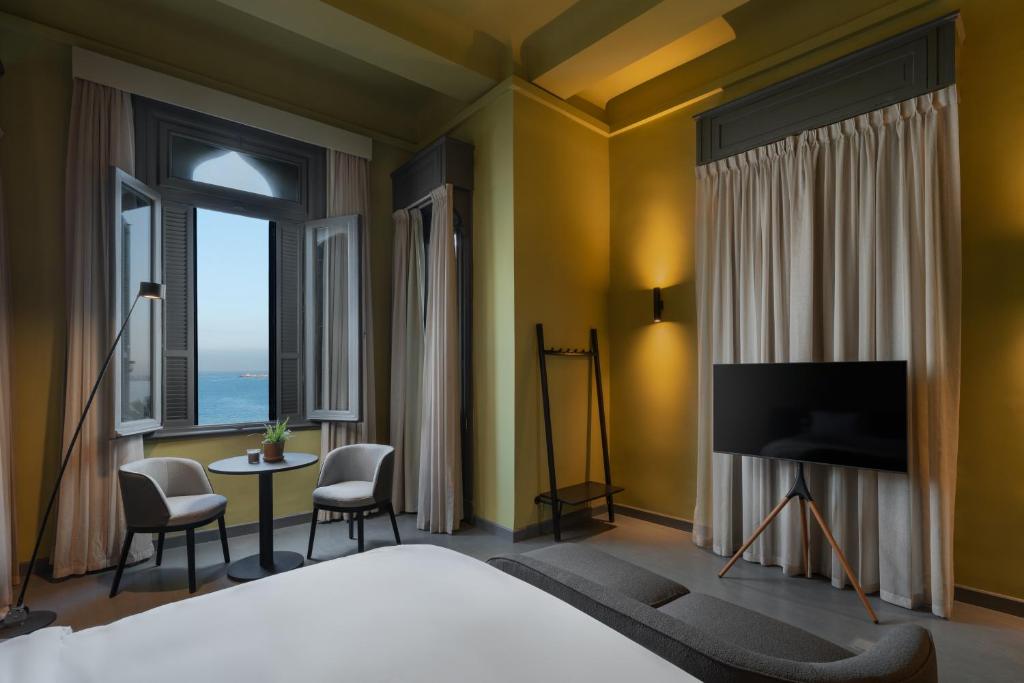 a hotel room with a bed and a television at grey l studio apartments Corniche Alexandria in Alexandria