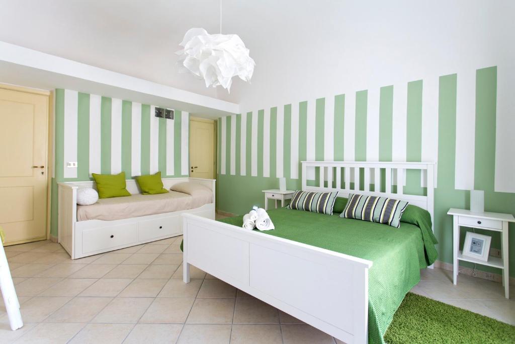 1 dormitorio con paredes de rayas verdes y blancas y 1 cama en Le Scale Apartment, en Palermo