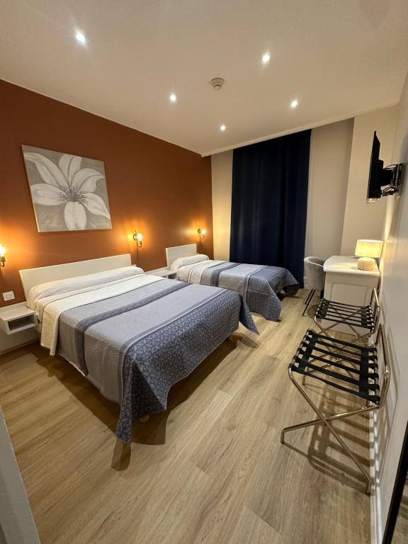 um quarto de hotel com duas camas e uma cadeira em Hotel Azur em Lyon