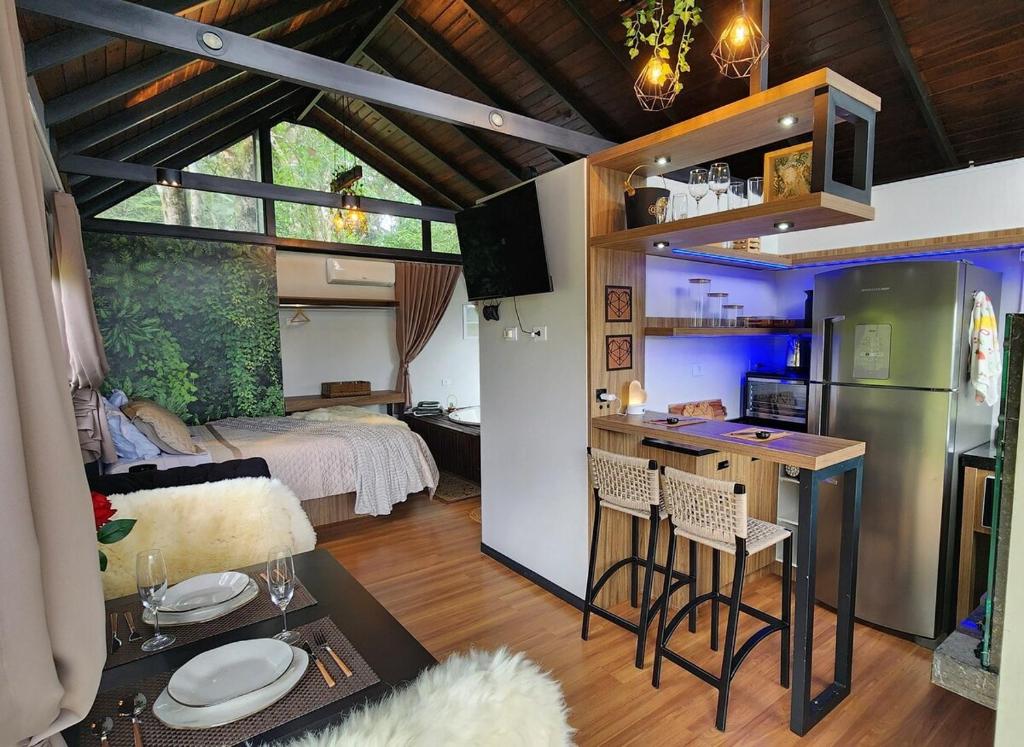 ein kleines Zimmer mit einer Küche und einem Schlafzimmer in der Unterkunft Linda Cabana com Vista Incrível nas Montanhas com Trilha, Cachoeira e Alexa in Campo Largo
