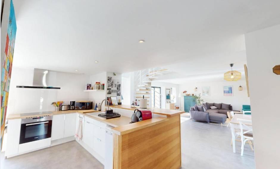 eine Küche und ein Wohnzimmer mit weißen Wänden in der Unterkunft Maison familiale entre mer et campagne in Putot-en-Bessin