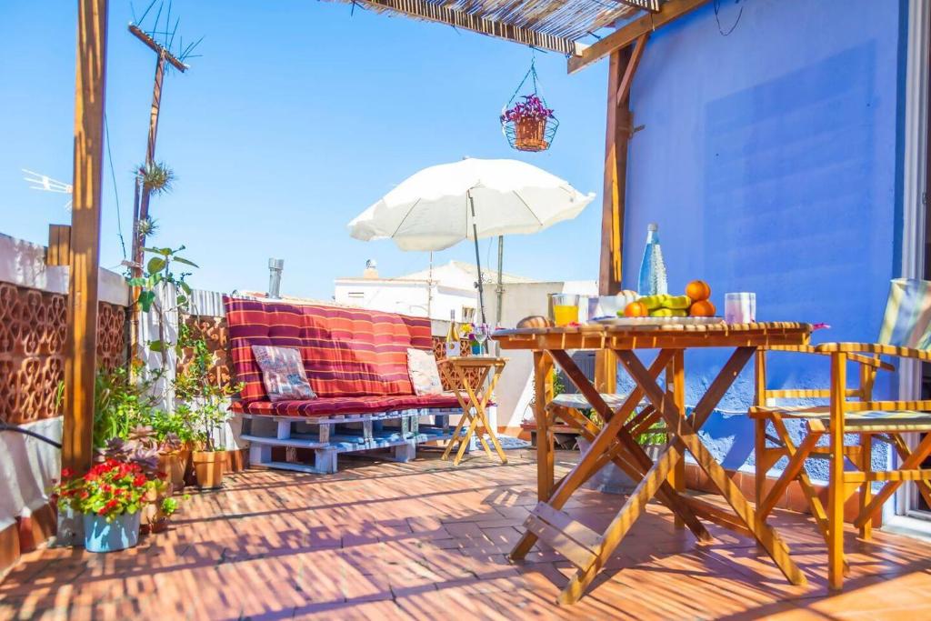 a patio with a table and a chair and an umbrella at Vilamurada • Terraza con vistas al casco antiguo in Denia