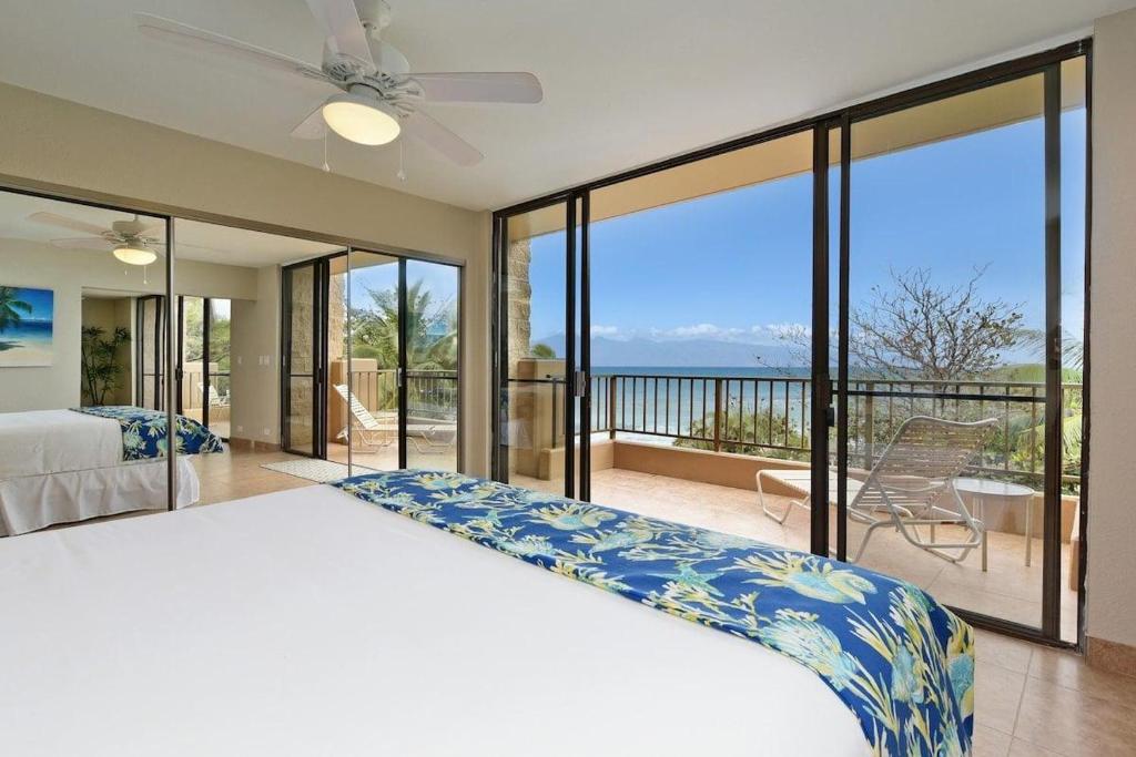 卡哈纳Paki Maui 424 · PM424 BeachFront 2BD w Ocean View的一间带床的卧室和一个可欣赏美景的阳台