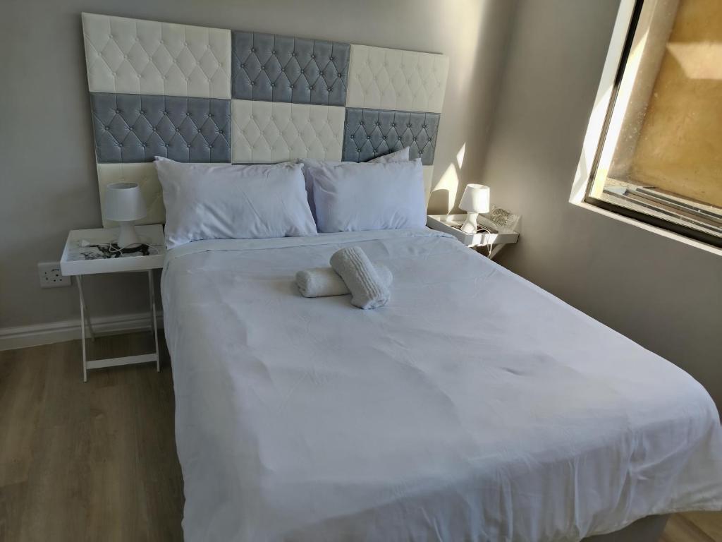 a large white bed with two pillows on it at Cosmic View Lodge in East London