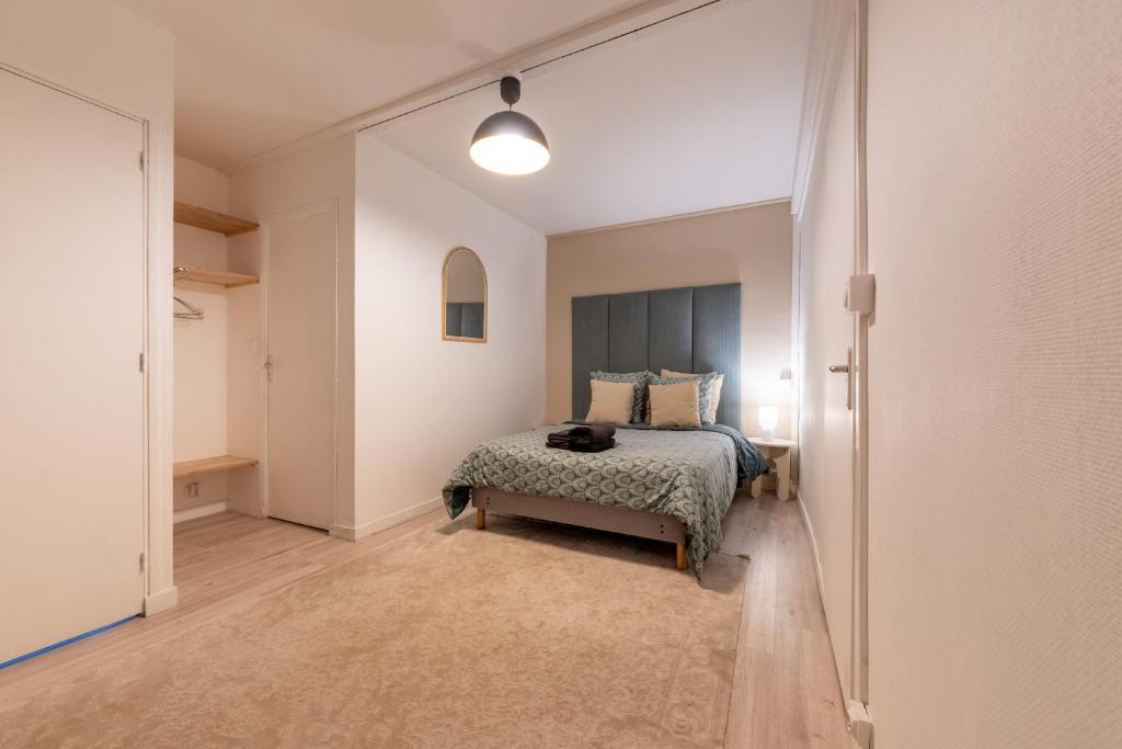a bedroom with a bed and a rug in a room at Le Rétro with private parking in Reims