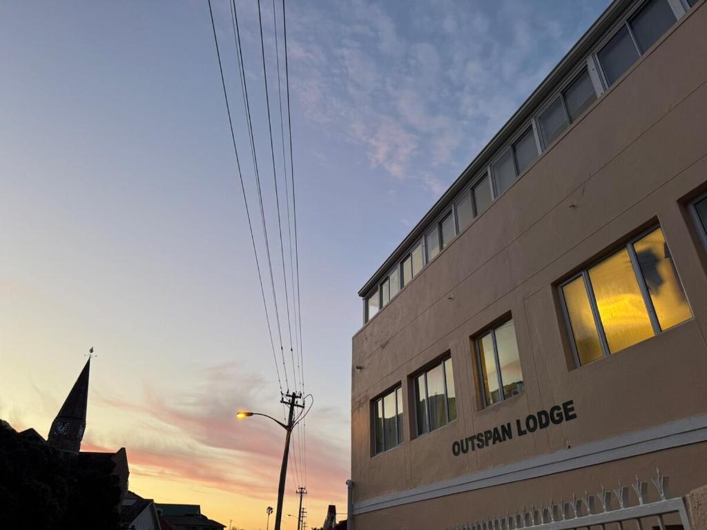 a building with the words cincinnati lodge on the side of it at Outspan Lodge in Fish hoek