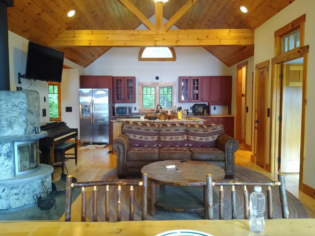 Una sala de estar con un sofá y una cocina. en 3 Cabins with Sauna on Lake Monomonac by Mount Monadnock, en Rindge