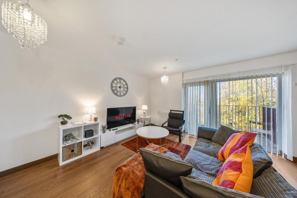 a living room with a couch and a tv at Stylish long & short stay flat with parking & Wifi sleeps 5 in Maidstone