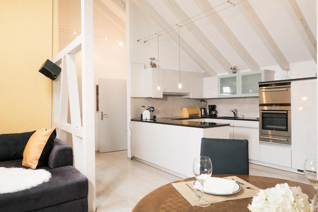 a kitchen and living room with a couch and a table at Apartment Hinterberg in Amden