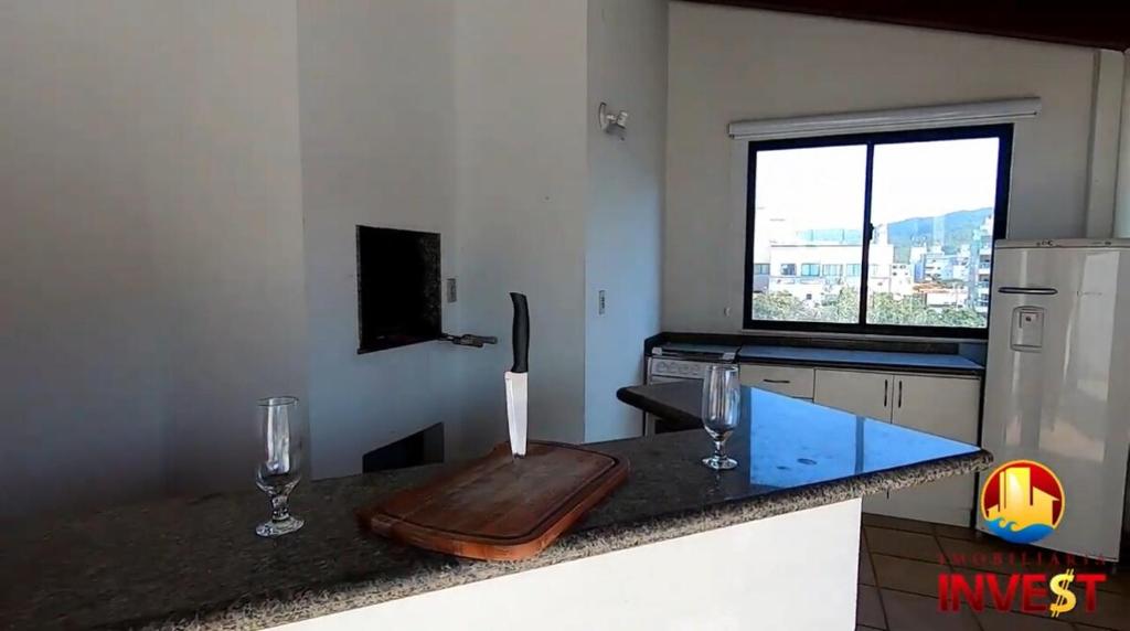 a kitchen with a counter with two wine glasses at Cobertura duplex Bombas in Bombinhas