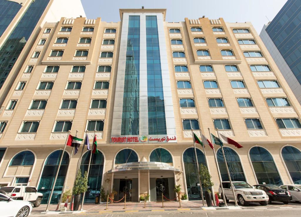 um edifício com bandeiras à sua frente em Tourist Hotel em Doha