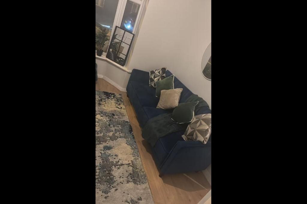 Sofá azul en la sala de estar con ventana en 23 Ash road, en Moffat