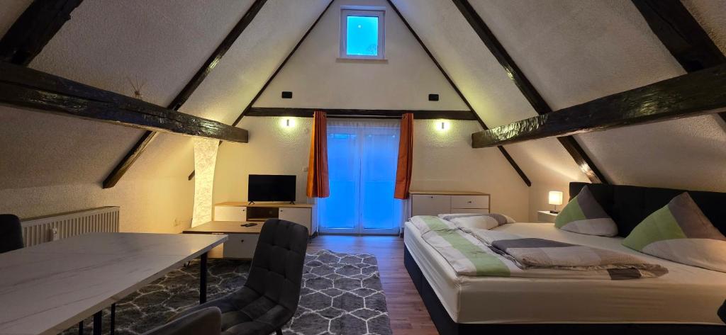a room with a bed and a table and a blue door at Ferienwohnung "Dachblick" Bad Elster in Bad Elster